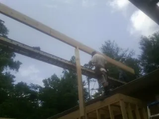 Carpenter setting a ridge beam over a new addition frame — Ice Dam Removal by Roofing Brothers in Elk City