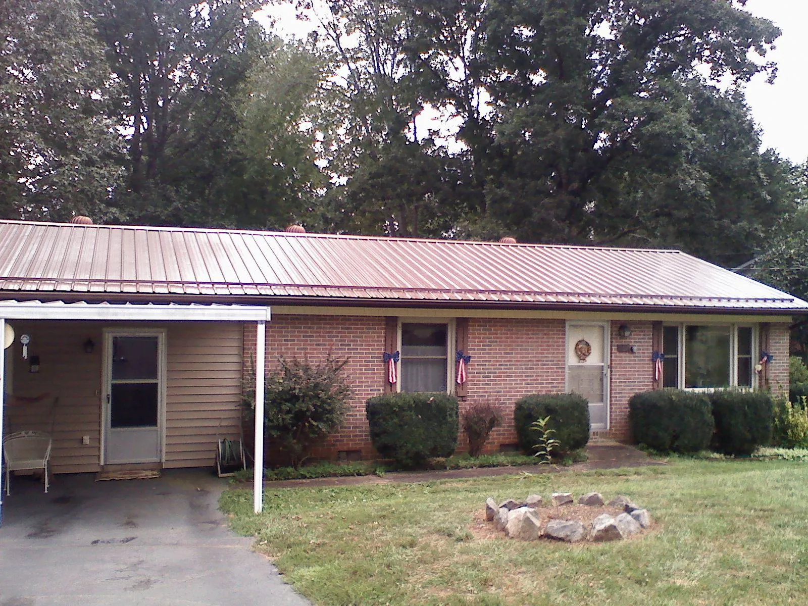 Bronze metal roof and carport on a brick ranch home — Roof Repair work by our crew in Elk City