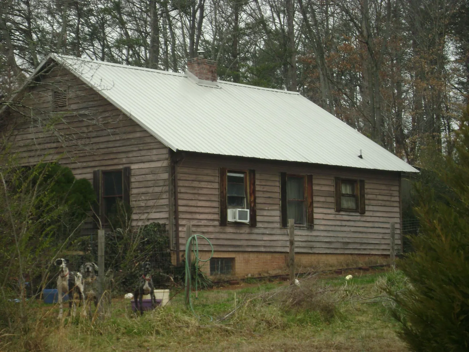 White metal roof on an old wood sided farmhouse, from a Metal Roof Installation job in Elk City